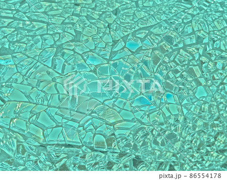 ターコイズやペールグリーンに光る細かくひび割れたガラスの鏡の背景画像 86554178