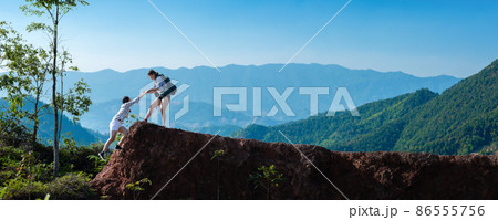 Asian hiking help each other on mountains Asian hiking help each other on mountains 86555756