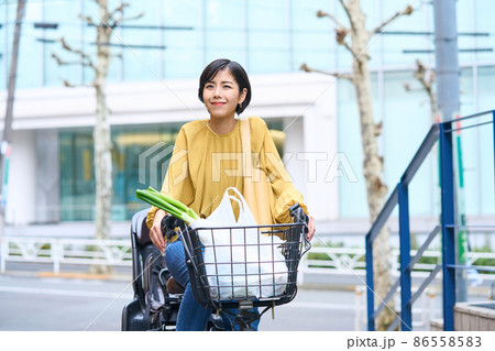 自転車に乗ってスーパーで買い出しをするママ 自転車に乗ってスーパーで買い出しをするママ 86558583