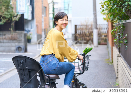 自転車に乗ってスーパーで買い出しをするママ 自転車に乗ってスーパーで買い出しをするママ 86558591
