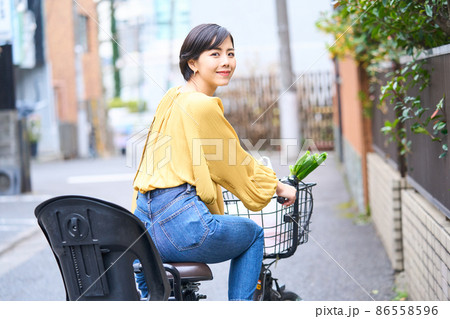 自転車に乗ってスーパーで買い出しをするママ 自転車に乗ってスーパーで買い出しをするママ 86558596