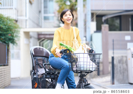 自転車に乗ってスーパーで買い出しをするママ 自転車に乗ってスーパーで買い出しをするママ 86558603