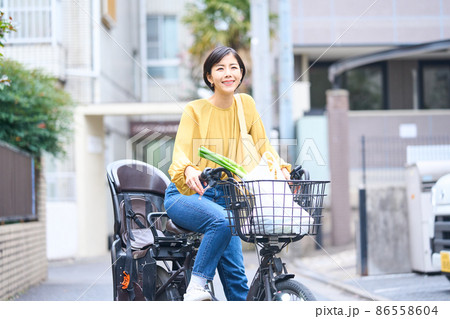 自転車に乗ってスーパーで買い出しをするママ 自転車に乗ってスーパーで買い出しをするママ 86558604