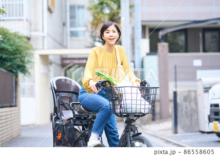 自転車に乗ってスーパーで買い出しをするママ 86558605