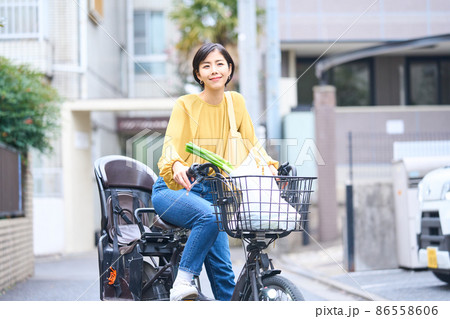 自転車に乗ってスーパーで買い出しをするママ 86558606