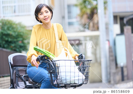 自転車に乗ってスーパーで買い出しをするママ 86558609
