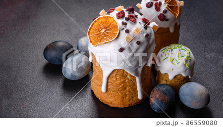 Festive cakes with white glaze, nuts and raisins with Easter eggs on the festive table Festive cakes with white glaze, nuts and raisins with Easter eggs on the festive table 86559080