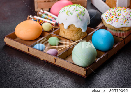 Festive cakes with white glaze, nuts and raisins with Easter eggs on the festive table Festive cakes with white glaze, nuts and raisins with Easter eggs on the festive table 86559096