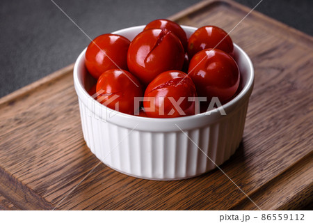 Delicious red canned cherry tomatoes in white piala 86559112