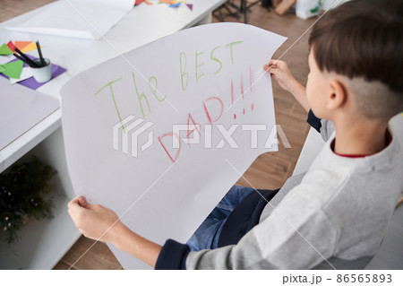 Caucasian boy holding placard with The best dad sign for the fathers day Caucasian boy holding placard with The best dad sign for the fathers day 86565893