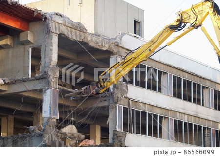 老朽化した公共建造物の解体作業をする重機 86566099