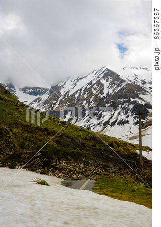 Mountain road littered with snow and trees. The convergence of an avalanche of snow. Clearing the road. 86567537