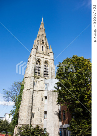 青空の下の石造りの大きな突起の付いた教会　ロンドン郊外の街並み 86567703