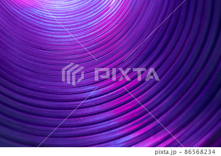 Ridged texture. Blur glow background. Fluorescent embossed tunnel wall. Iridescent radiance. Defocused neon purple pink color light on curved corrugated abstract overlay. 86568234