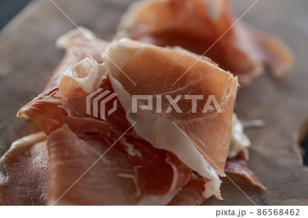 Thin slices of jamon on olive wood board 86568462