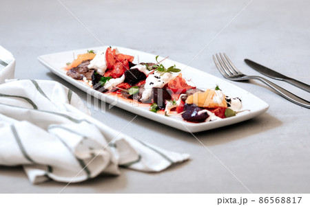 fillet and fresh vegetable salad of lettuce, arugula, spinach, cucumber and tomato. Healthy lunch menu. fillet and fresh vegetable salad of lettuce, arugula, spinach, cucumber and tomato. Healthy lunch menu. 86568817