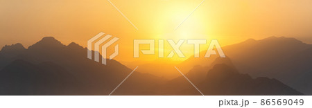 orange panorama - misty mountains at sunset orange panorama - misty mountains at sunset 86569049