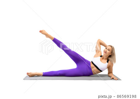 Female workout. Attractive smiling fit woman lying on a mat and does side kicks exercise, isolated on white. Female workout. Attractive smiling fit woman lying on a mat and does side kicks exercise, isolated on white. 86569198