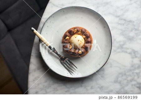 Chocolate caramel pie with nuts in a white plate on a marble background Chocolate caramel pie with nuts in a white plate on a marble background 86569199