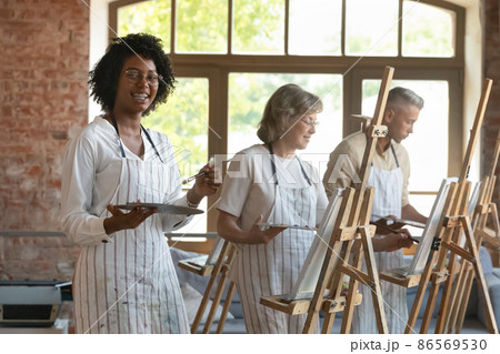 Happy nerdy art school young African student drawing in studio 86569530