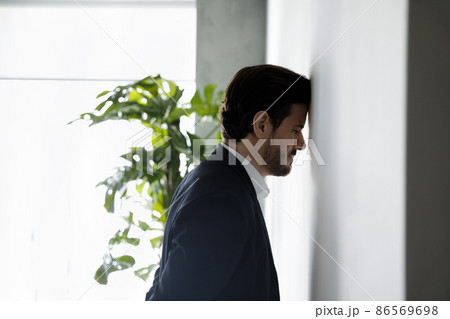 Frustrated desperate business man leaning head on wall 86569698
