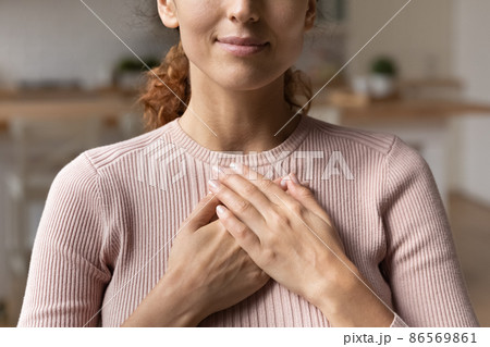 Sincere woman put folded palms on chest feeling gratitude closeup 86569861