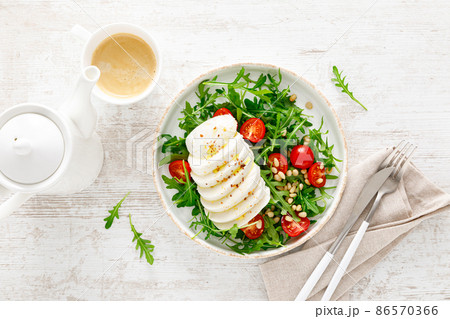 Salad with arugula, mozzarella cheese and pine nuts. Breakfast. Ketogenic, keto or paleo diet. Healthy food. Top view Salad with arugula, mozzarella cheese and pine nuts. Breakfast. Ketogenic, keto or paleo diet. Healthy food. Top view 86570366
