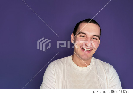 Portrait of a caucasian man smiling and happy isolated on color of the year 2022 very peri Portrait of a caucasian man smiling and happy isolated on color of the year 2022 very peri 86573859