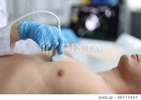 Doctor performs chest ultrasound on man in hospital closeup Doctor performs chest ultrasound on man in hospital closeup 86573934