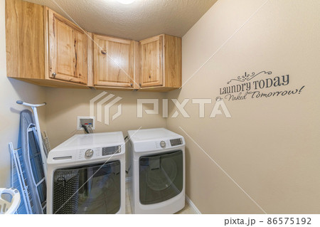 Small laundry room with writings on the beige wall Small laundry room with writings on the beige wall 86575192