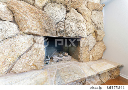Fireplace interior with large stones surround and hearth Fireplace interior with large stones surround and hearth 86575841