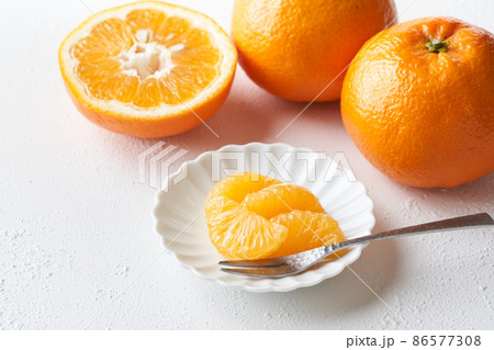 皮を剥いて皿に盛り付けた伊予柑 86577308