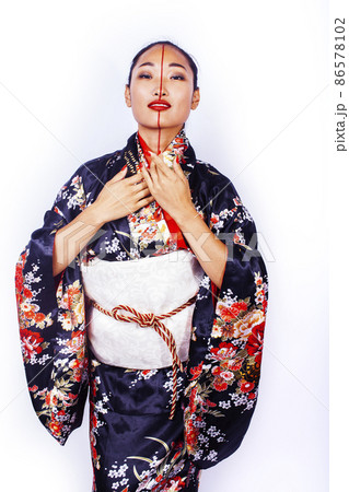 young pretty geisha in black kimono posing isolated on white background, asian ethno young pretty geisha in black kimono posing isolated on white background, asian ethno 86578102