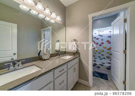 Bathroom with light gray interior and shower curtain with printed fishes design on a shower room Bathroom with light gray interior and shower curtain with printed fishes design on a shower room 86578206