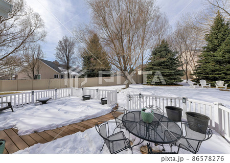 Outdoor patio on a deck of a house with metal chairs and table 86578276