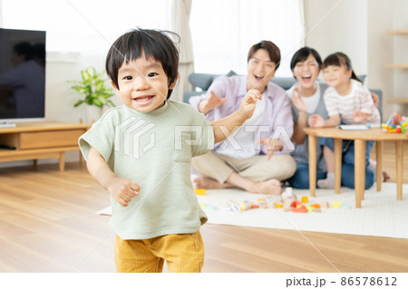 リビングではしゃぐ子供と家族 86578612