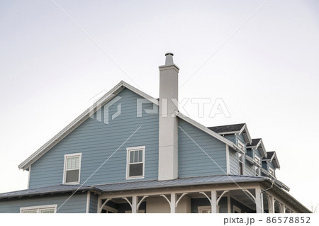 Side view of a cape cod home against the white sky background Side view of a cape cod home against the white sky background 86578852