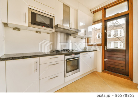 Interior of a stylish modern kitchen room with the wooden brown door 86578855