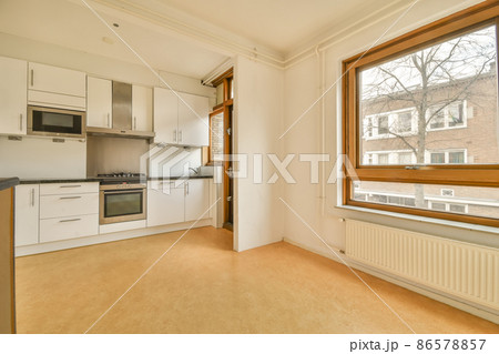 Interior of a stylish modern kitchen room with white cabinets and a white fridge 86578857