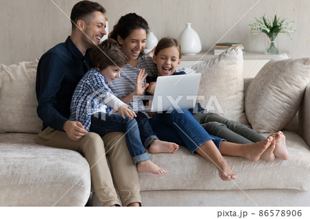 Happy parents with two kids making video call together 86578906