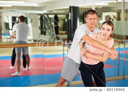 Woman learning elbow strike move during self-defense training 86578960