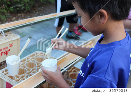 流しそうめんを食べる男の子 86579013