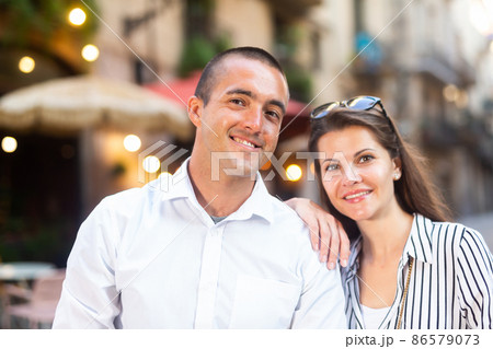 Young couple strolling through sunny city streets Young couple strolling through sunny city streets 86579073