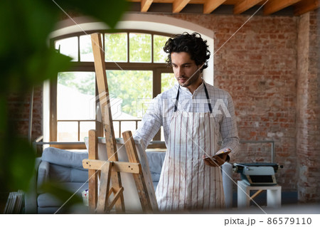 Focused busy attractive young artist student guy training painting skills Focused busy attractive young artist student guy training painting skills 86579110