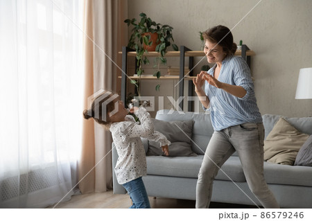 Overjoyed small kid girl dancing with mum. 86579246