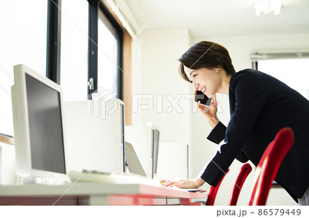 オフィスで電話する女性 オフィスで電話する女性 86579449