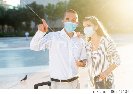 Tourist couple in medical masks visiting city attractions 86579586