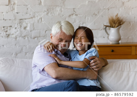 Happy cheerful granddad cuddling, tickling excited laughing grandkid boy 86579592