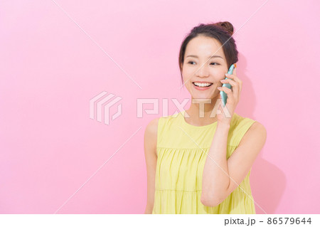 スマホ　女性　ピンク背景 86579644