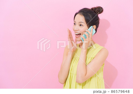 スマホ 女性 ピンク背景 スマホ 女性 ピンク背景 86579648